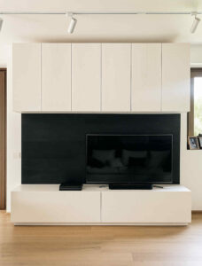 parete attrezzata moderna, mobile soggiorno bianco e nero, pannello TV in legno, pensili a soffitto, mobile artigianale su misura, arredo zona giorno elegante, parete salotto contemporanea, base con cassettoni push and pull, mobili frassino su misura, mobili soggiorno Made in Italy